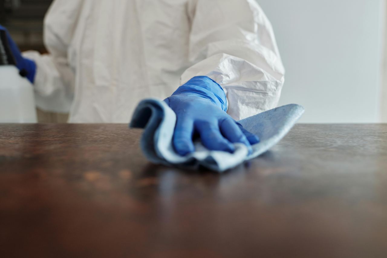 Profesional de Limpiezas Artaza limpiando una superficie con guantes y bayeta